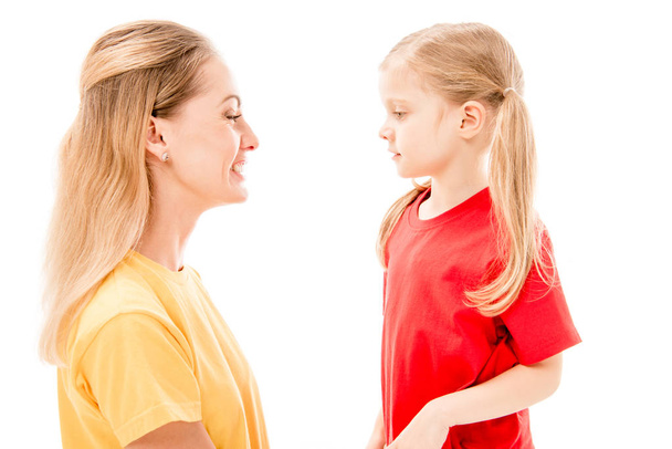side view of happy mother and daughter looking at each other isolated on white - Foto, afbeelding
