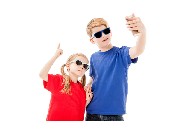 two kids in sunglasses taking selfie isolated on white - 写真・画像
