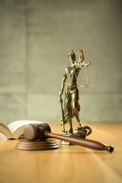 Νόμος και δικαιοσύνη, δικαστής σφυρί, βιβλίο με το άγαλμα της τυφλής θεάς Θέμης σε ξύλινο τραπέζι. - Φωτογραφία, εικόνα