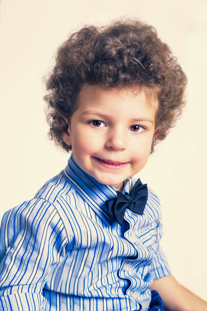 A kid portrait with curly hair on studio - 写真・画像