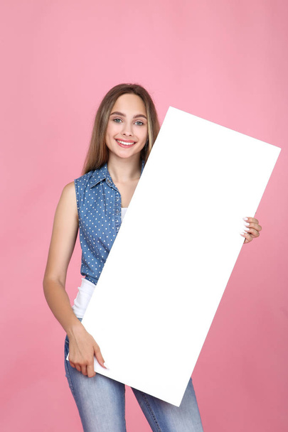 Beautiful young woman holding white blank board on pink backgrou - Foto, Imagem