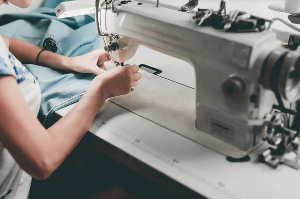 Dressmaker hands sews fabrics on sewing machine - Fotó, kép