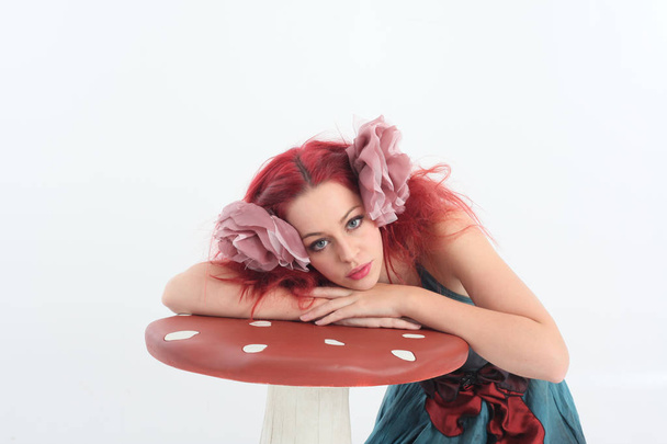 Ritratto ravvicinato della ragazza dai capelli rossi che indossa un costume da fata, in posa su uno sfondo bianco dello studio
. - Foto, immagini