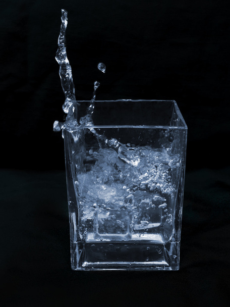 hielo cayendo sobre un vaso de agua
 - Foto, Imagen