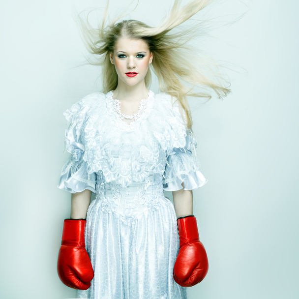 Beautiful woman in white dress with boxing gloves. Boxer bride - Фото, зображення