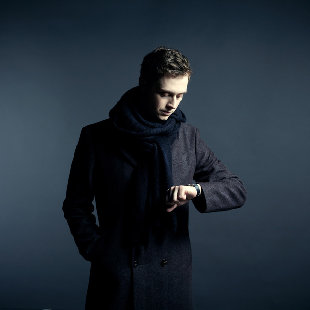 Portrait of handsome stylish man in coat with watch - 写真・画像