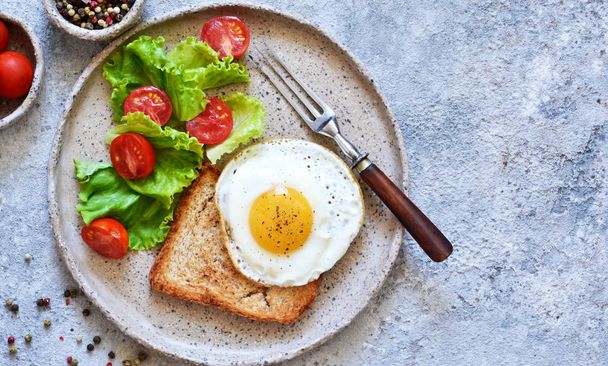 Classic breakfast - bread toast, fried egg and salad. View from  - Foto, Bild