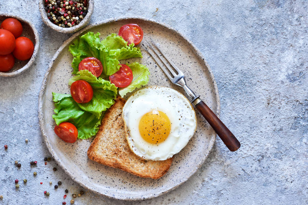 Classic breakfast - bread toast, fried egg and salad. View from  - Zdjęcie, obraz
