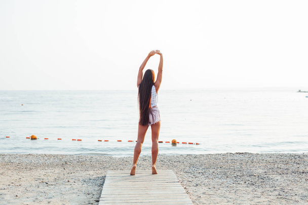 Schöne Frau mit langen Haaren spaziert am Strand - Foto, Bild