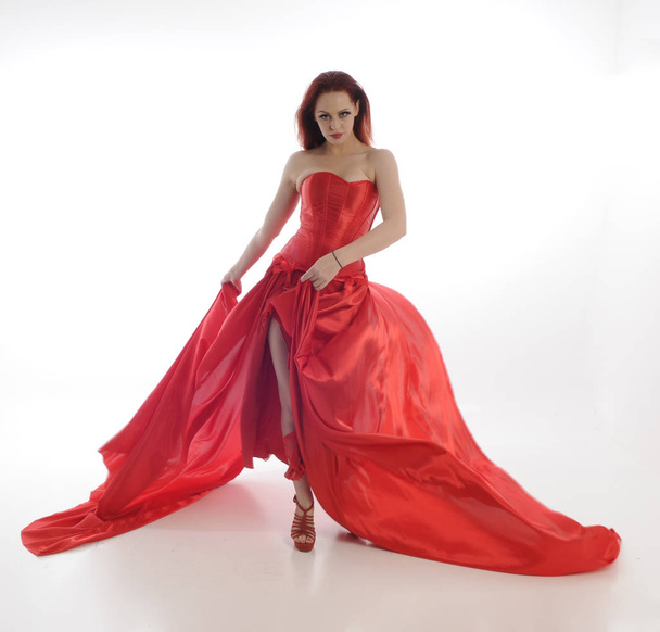 retrato de longitud completa de la mujer con capa de gancho de montar rojo y vestido de seda largo. pose de pie, aislado sobre fondo blanco del estudio
 - Foto, imagen