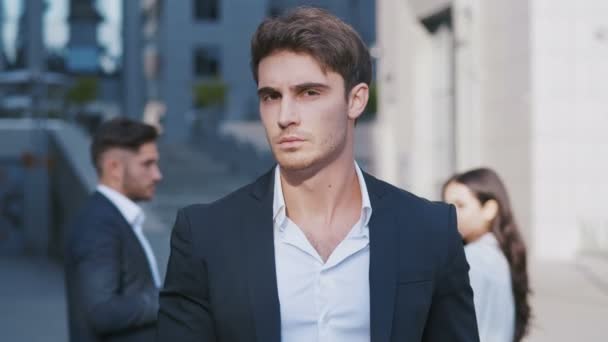 Portrét úspěšného mladého podnikatele, který stojí ve městě poblíž obchodního centra a požívá profesionálního životního stylu. Pohledný mužský zaměstnanec, který se dívá na kameru. - Záběry, video
