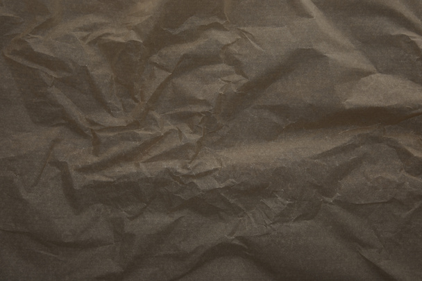 Draufsicht auf dunkelbeige zerknüllte Pergamentpapieroberfläche mit Kopierraum - Foto, Bild