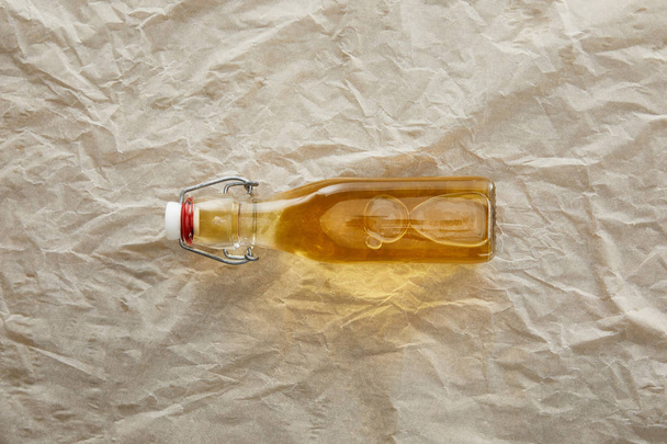 top view of bottle of apple cider on parchment paper with copy space - Foto, Imagem