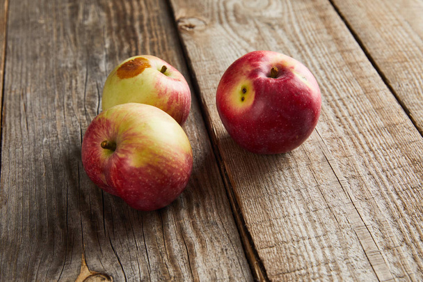 rolników jabłka z małym zgniłe miejscu na powierzchni drewnianej - Zdjęcie, obraz