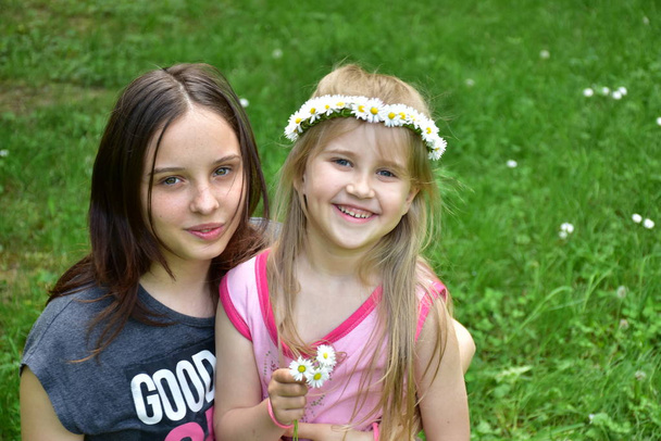 retrato de dos niñas con una corona de margaritas en la cabeza
, - Foto, Imagen