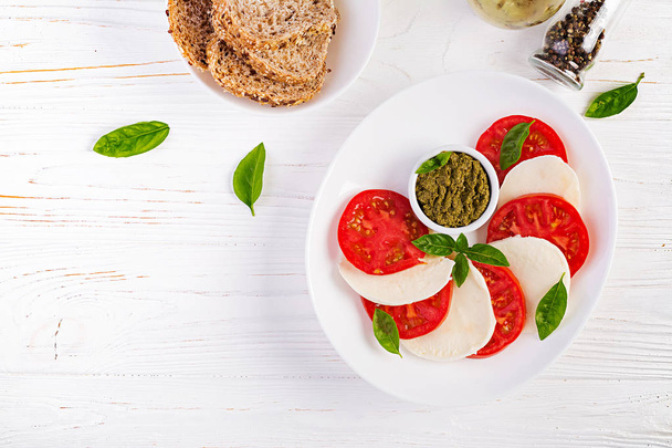 Salada Caprese italiana tradicional com mussarela, tomate, manjericão. Vista superior, sobrecarga
 - Foto, Imagem