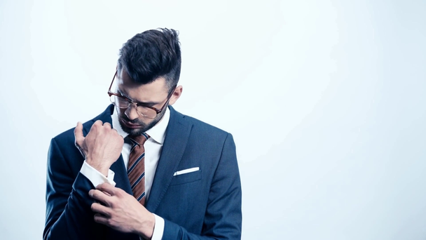 handsome man touching suit on white  - Video, Çekim