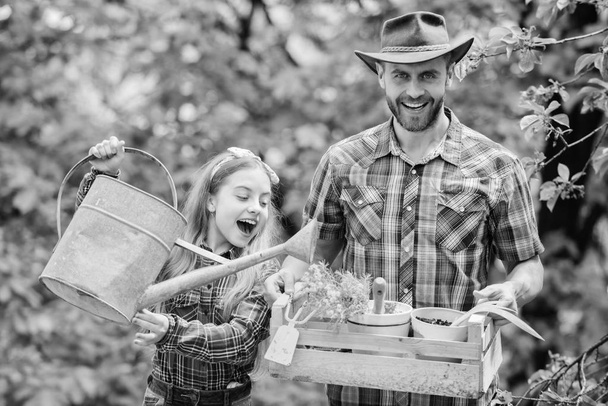 spring village country. little girl and happy man dad. earth day. ecology. Watering can and shovel. family farm. father and daughter on ranch. Working with flowers - Foto, Imagen