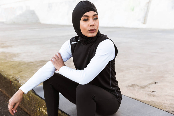 Attractive muslim sportswoman wearing hijab outdoors - Foto, afbeelding