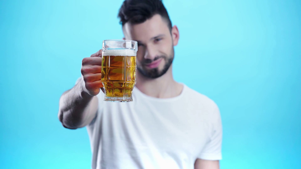 Selektiver Fokus des Mannes, der Glas mit Bier auf Blau hält - Filmmaterial, Video