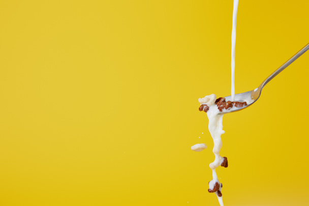 spoon with assorted cereal and milk splashes isolated on yellow - Foto, Imagem