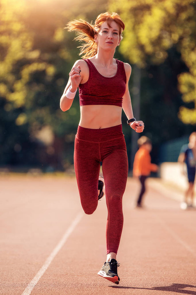 Picture of young attractive happy fitness woman running outside. - Photo, Image