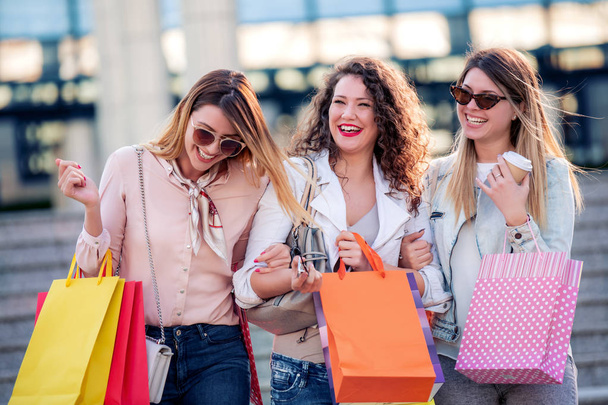 Grupa szczęśliwych kobiet przyjaciół z torby na zakupy uśmiechnięty i chodzenie w mieście, turystyka i zakupy koncepcji  - Zdjęcie, obraz
