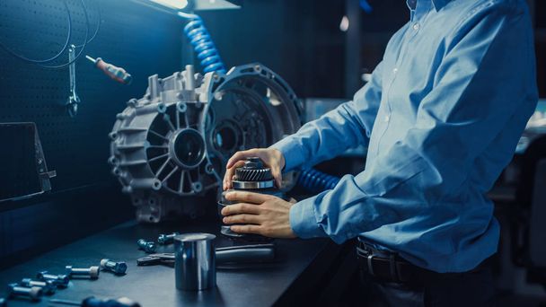 Professional Automotive Engineer in Glasses is Working on Transmission Gears in a High Tech Innovative Laboratory with a Computer Screens. - Photo, Image
