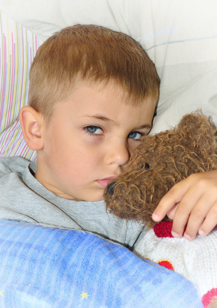 Niño enfermo con oso de peluche
 - Foto, imagen