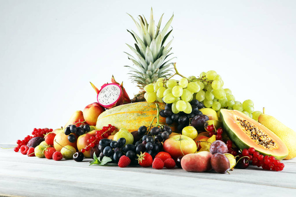 Tropische vruchten achtergrond, veel kleurrijke rijpe vruchten met stro - Foto, afbeelding