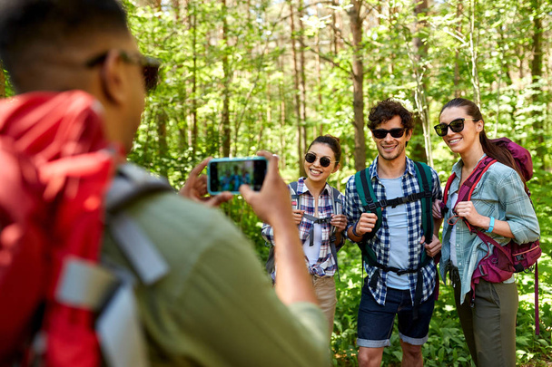 friends with backpacks being photographed on hike - Foto, Bild