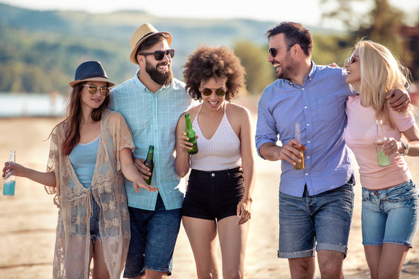 Skupina přátel párty na pláži. Mladí lidé slaví během letních prázdnin. - Fotografie, Obrázek