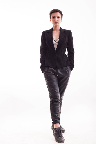 Полное тело красивой молодой женщины в черных кожаных брюках на белом фоне
 - Фото, изображение