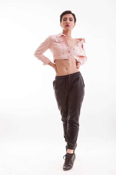 Beautiful fashion model walking toward and posing to the camera in studio over white background - Valokuva, kuva