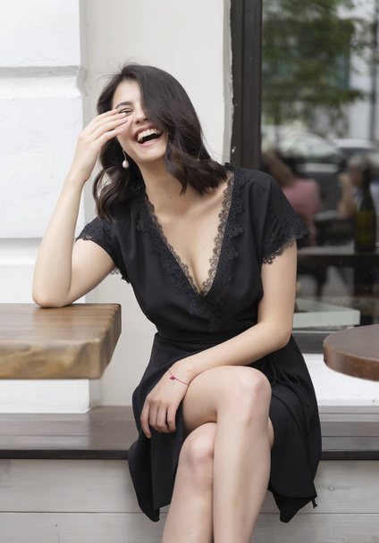 Beautiful elegant brunette girl wearing a black dress with a sex - Foto, Imagen
