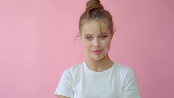 Girl in the studio on a pink background.Advertising, hair products, beauty salon, cosmetics, clothing. Fashion, boutique. Pink. - Кадри, відео