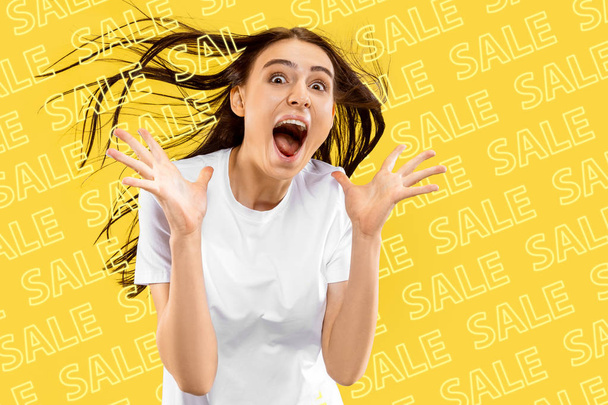 Portrait of young woman on yellow background, black friday - Foto, Imagem