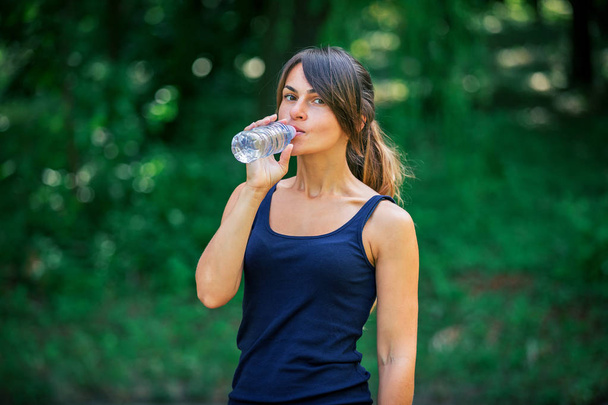 a girl drinks water after sport - Фото, изображение