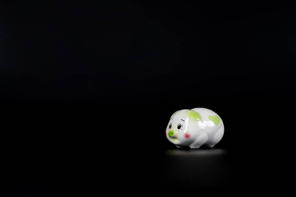 Isolated sad piggy bank on the black background with copy space. - Photo, Image