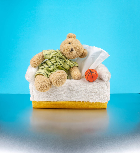 Teddy Bear hordani a pizsama és üljön a szövet doboz kosàrba - Fotó, kép