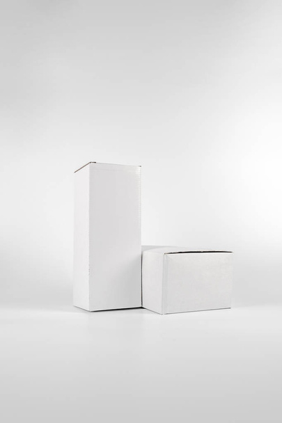 Fehér két papírdoboz-magas és kövér feküdt a fehér háttér - Fotó, kép