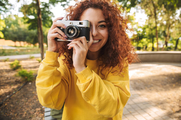 Happy young girl with red curly hair - 写真・画像