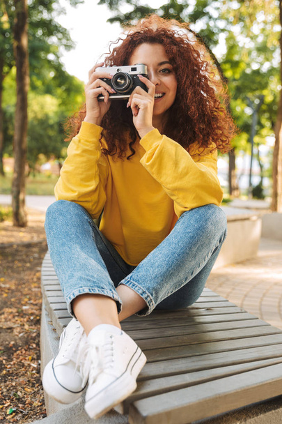Happy young girl with red curly hair - 写真・画像