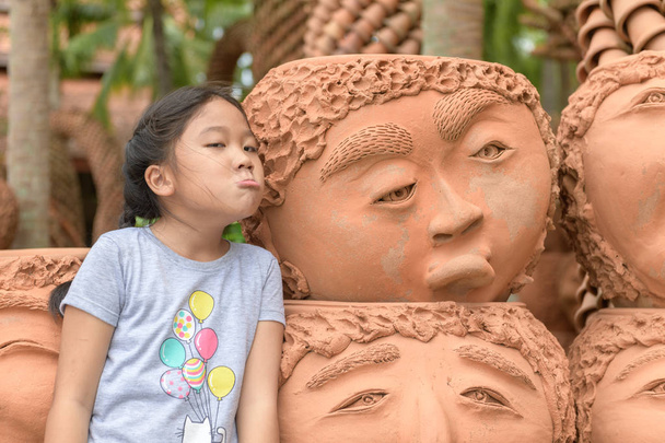 Дівчина, що показує нудні або засмучені емоції біля глиняних горщиків
,  - Фото, зображення
