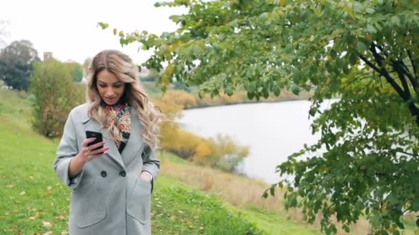 Blonde girl with smartphone and credit card make shopping - Záběry, video