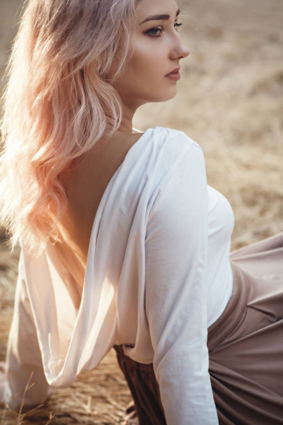 joven hermosa mujer en vestido con la espalda desnuda en un fondo de hierba seca, chica romántica relajarse solo en la naturaleza, retrato femenino natural
 - Foto, imagen