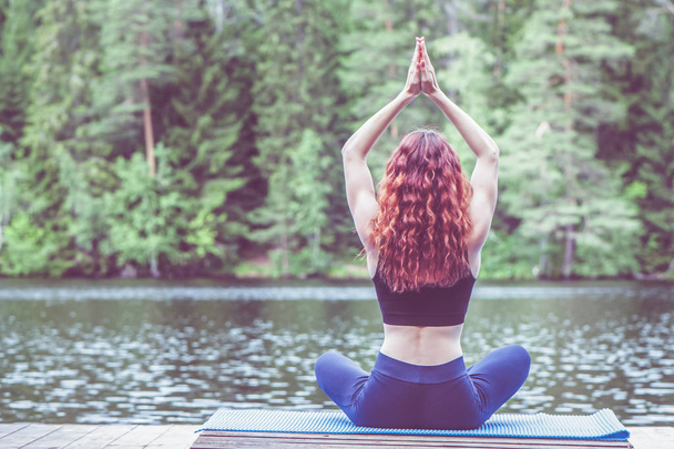 Chica joven practicando yoga en la naturaleza en el lago. Hembra hap
 - Foto, imagen