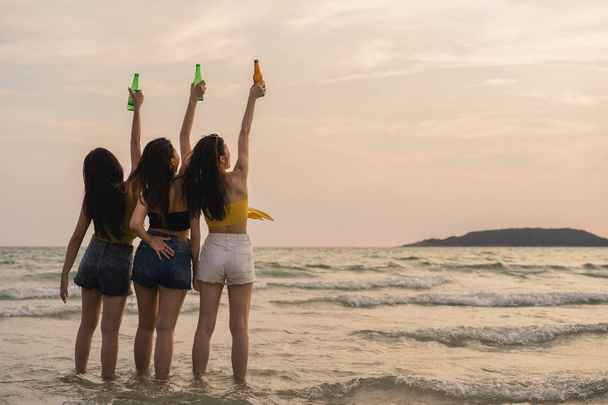 Groep Aziatische tiener meisjes met feest vieren op het strand, vrienden blij drinken bier op het strand op zee wanneer zonsondergang in de avond. Outdoor activiteit vrienden reizen vakantie vakantie zomer concept. - Foto, afbeelding