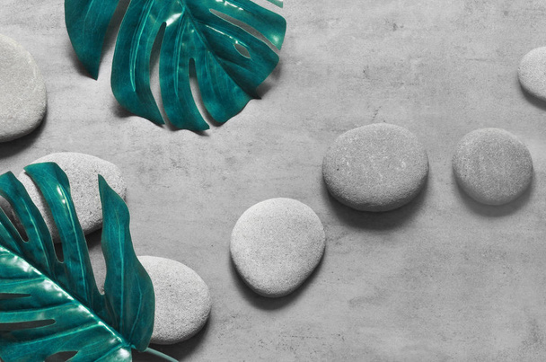 Flat lay composition with spa stones, palm leaves on grey background. - Foto, Bild
