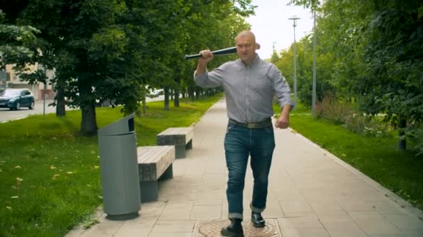 Delincuente caminando por la ciudad con un bate de béisbol
 - Imágenes, Vídeo